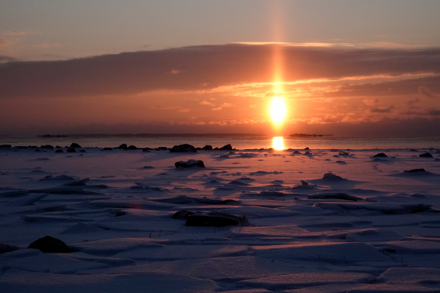 Aurinko laskee talvisessa maisemassa Aurinko laskee talvisessa maisemassa
